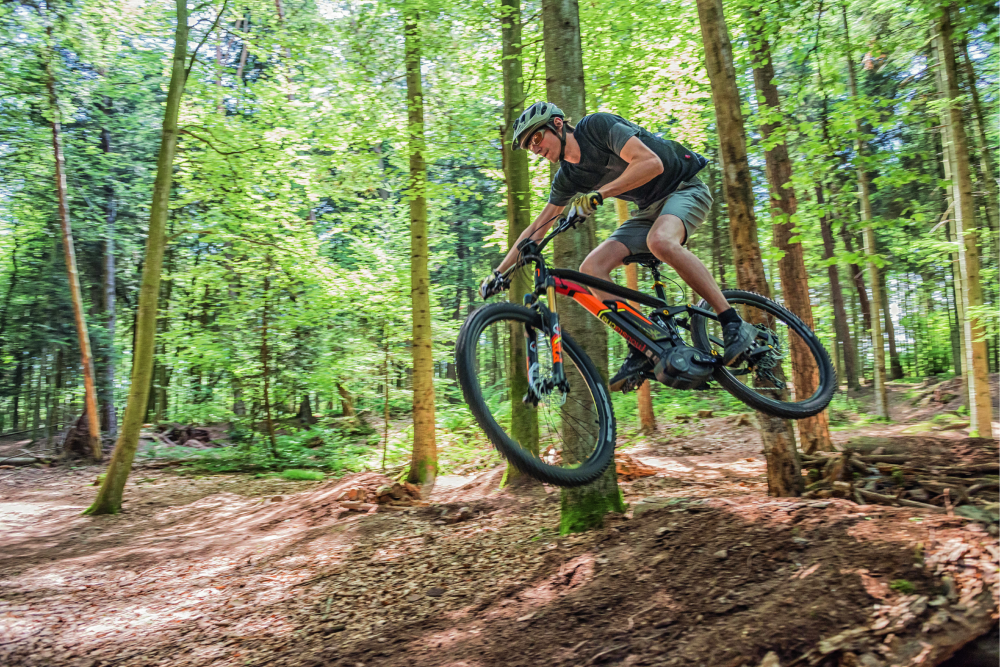 Vélo électrique Moustache en plein saut dans la forêt