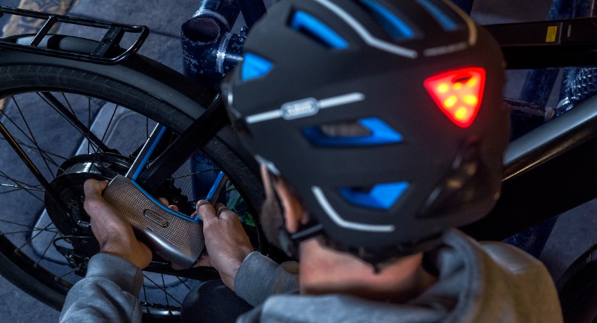 Cycliste attachant son vélo de nuit avec un antivol connecté