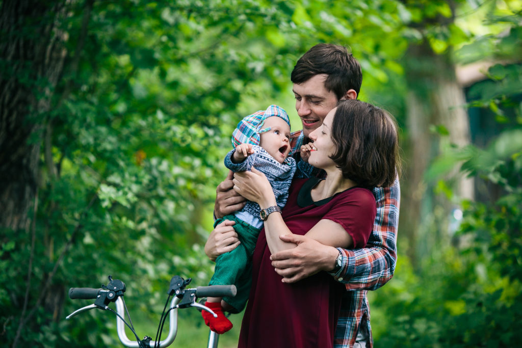 Couple avec bébé près d'un vélo pliant
