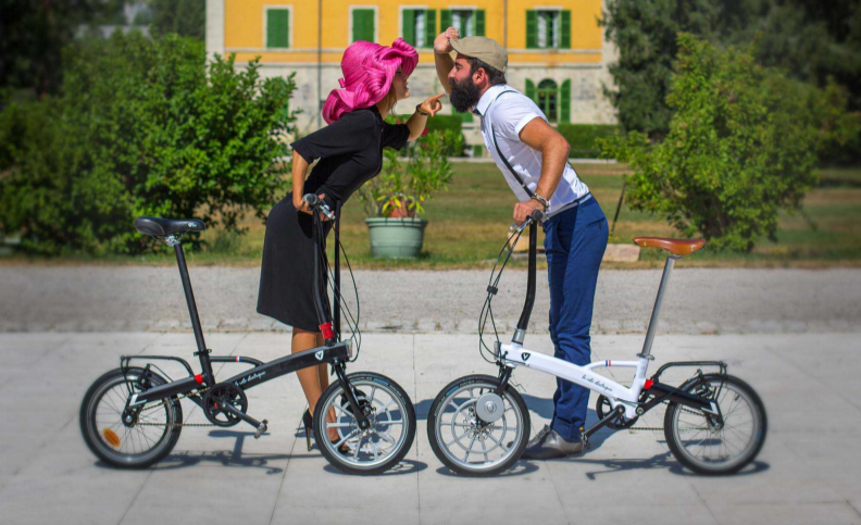 Couple avec chacun un vélo pliant se faisant face