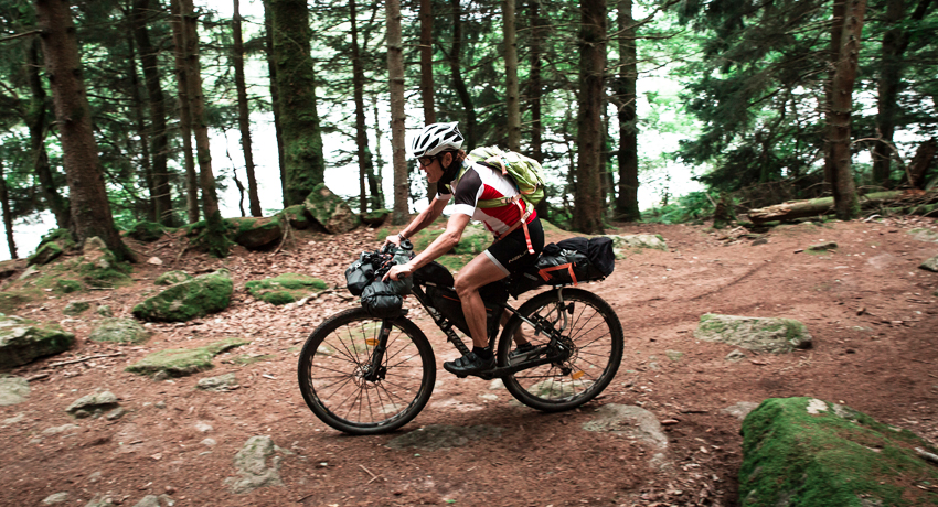 Cycliste sur un vélo gravel tout équipé avec sacoches bikepacking