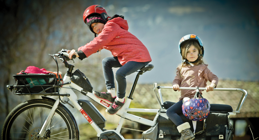Deux enfants sur un vélo longtail à l'arrêt