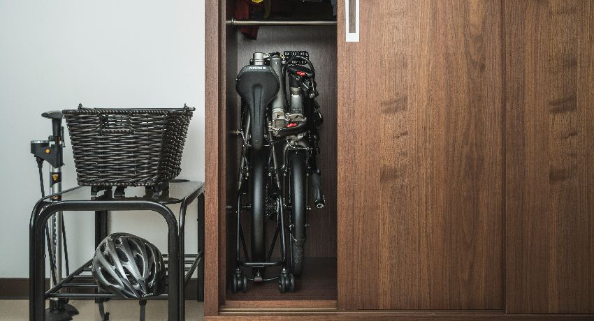Un vélo pliant rangé en position pliée dans un placard.