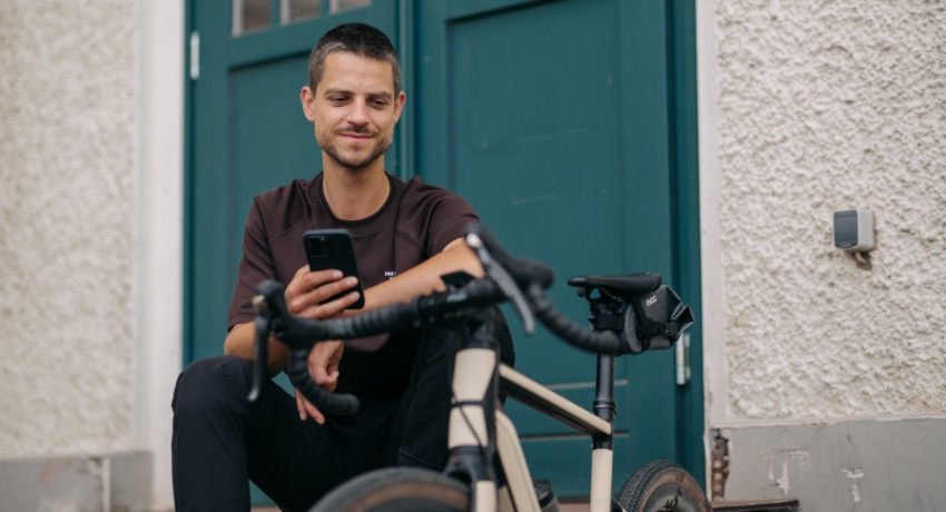 Un homme règle les paramètres de son gravel électrique grâce à l'application eBikeFlow.