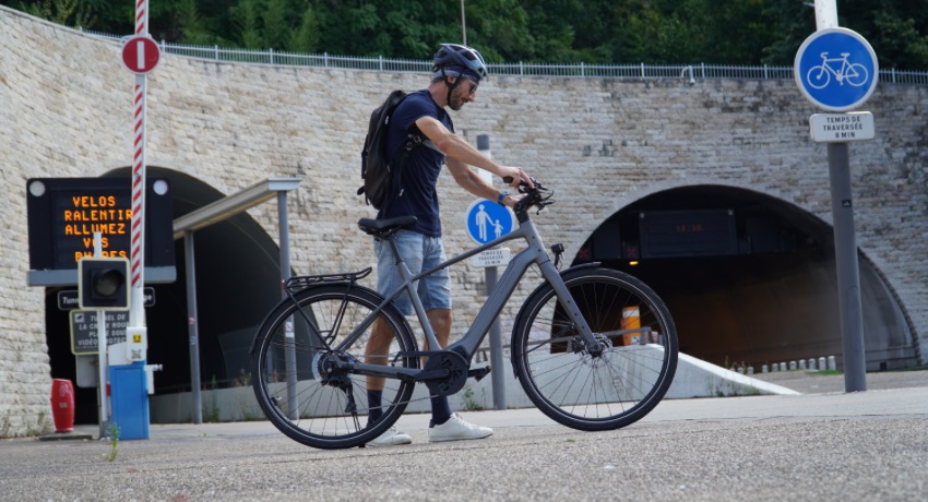 Un cycliste en ville s'apprête à enfourcher son Kalkhoff Endeavour L pour rentrer dans un tunnel cyclable.