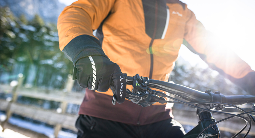 Gros plan sur une main gantée en train d'actionner un levier de frein pour vérifier son fonctionnement.